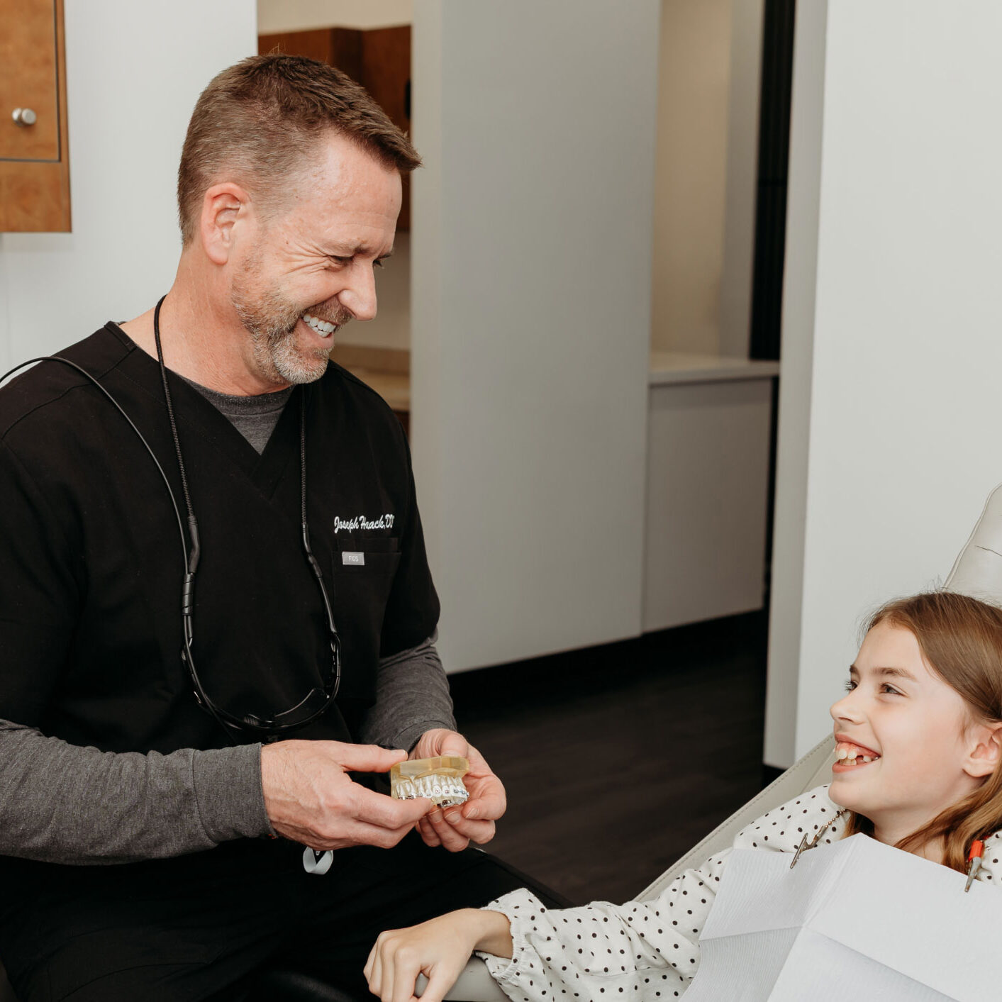 Dr. Haack showing teen patient a model of teeth with braces