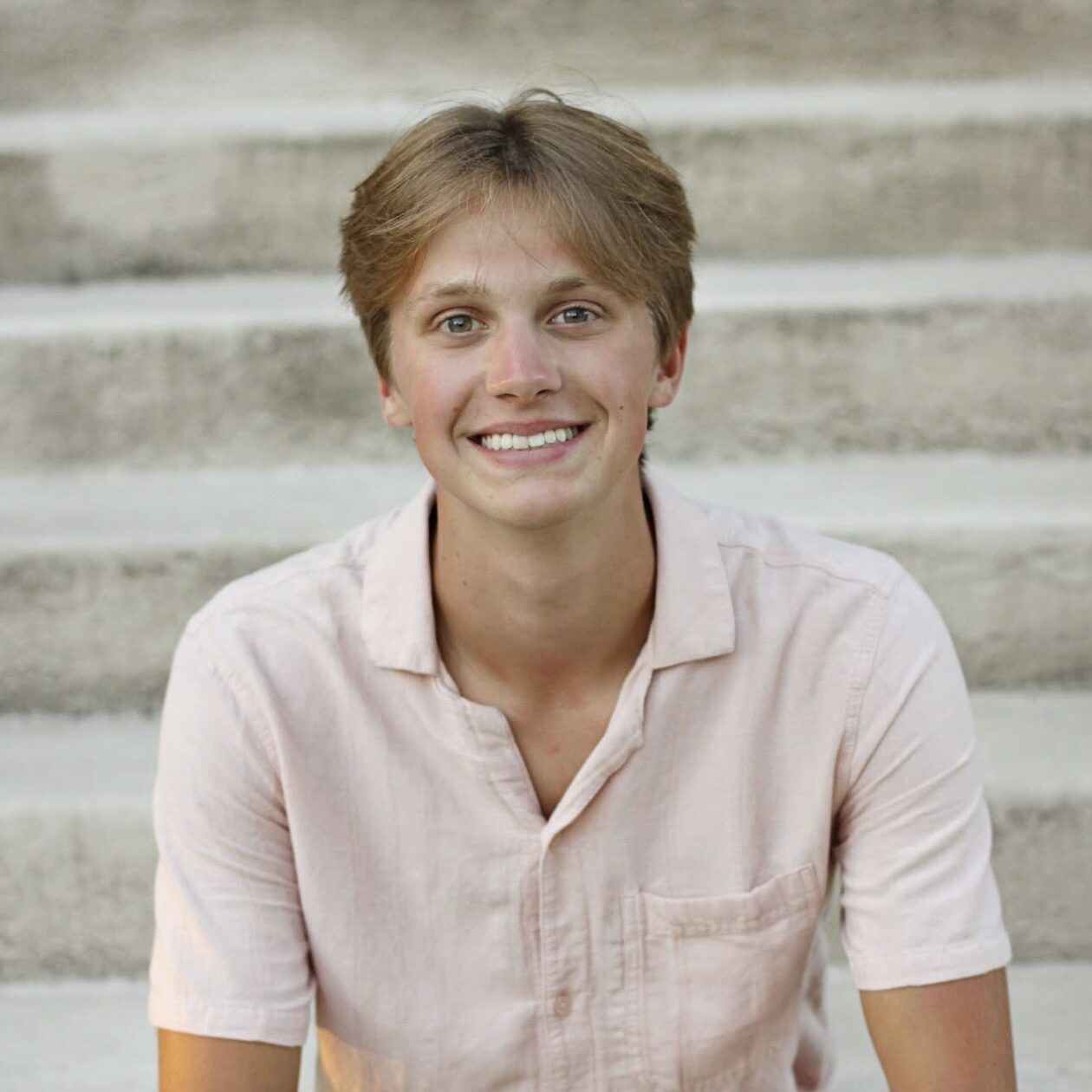 portrait of teen boy sitting on concrete steps